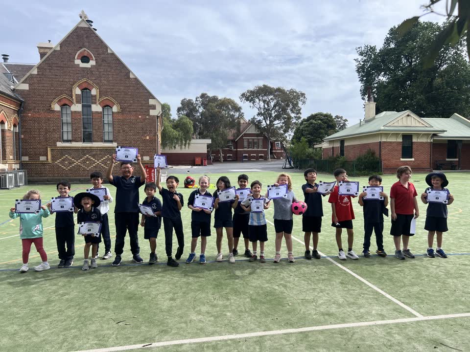 End-of-term certificates on the oval at a partner primary school